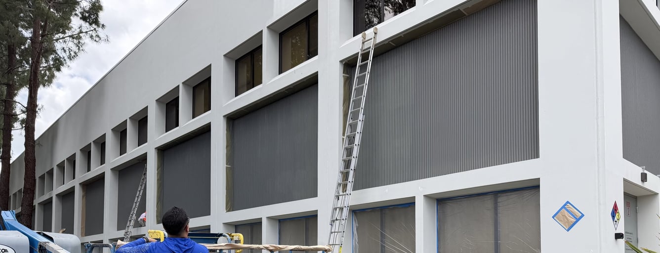 Diaz painter preparing a two-story office building with a boom lift