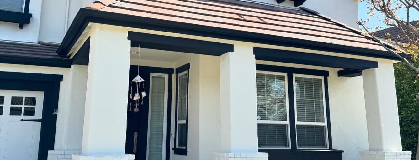 Two-story home with fresh white stucco and dark trim