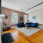 Apt 201 living room with exposed brick walls and hardwood floors