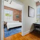 Apt 201 bedroom with exposed brick wall and windows