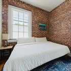 Apt 201 bedroom with brick walls and original windows