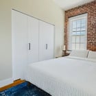 Apt 201 bedroom with built-in closet and brick wall