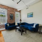Apt 201 living room with tall original windows and blue velvet sofa