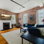 Apt 201 living room with decorative fireplace and brick walls