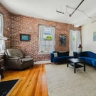 Apt 201 seating area with exposed brick and large windows
