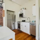 Apt 201 kitchen with stainless refrigerator and stacked laundry
