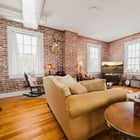 Corner of the living room in Apartment 301 with brick walls and windows facing three directions