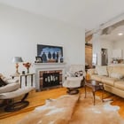 Living area in Apartment 301 with a decorative fireplace and the kitchen beyond