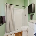 Apartment 303 bathroom with green walls, round mirror and granite vanity