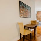 Apartment 303 dining table with the living area and exposed brick beyond