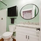 Apartment 303 bathroom with walk-in shower and round mirror