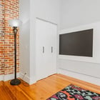 Apartment 303 bedroom with closet, floor lamp and exposed brick