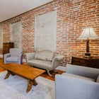 Apartment 303 sitting area with sofa, armchairs and bed beyond