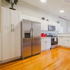 Apartment 303 kitchen with white cabinets, stainless steel appliances and hardwood floors