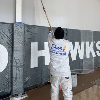 Diaz painter rolling a school gym wall
