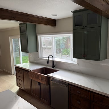 Sage green painted kitchen cabinets with farmhouse sink