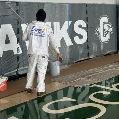 Diaz painter rolling a gym wall mural
