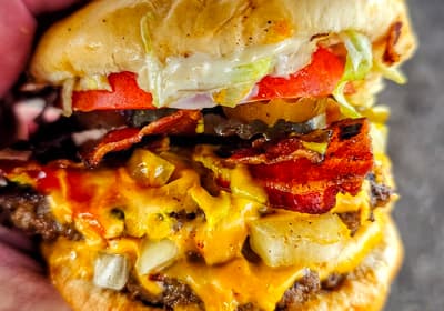 A double bacon cheeseburger with chili, onions and melted cheese