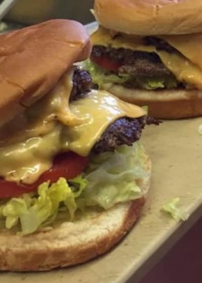 A double cheeseburger with lettuce and tomato