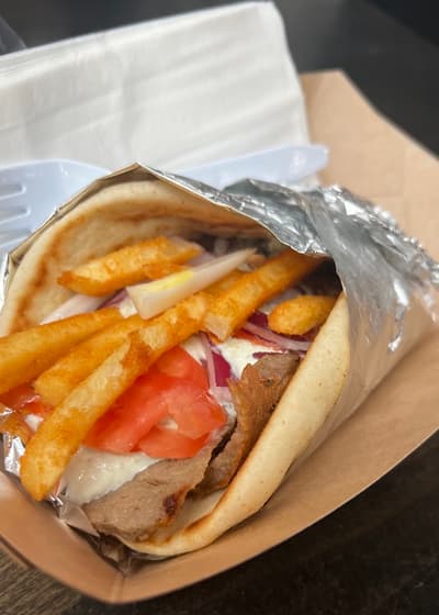 A gyro stuffed with fries and tomato