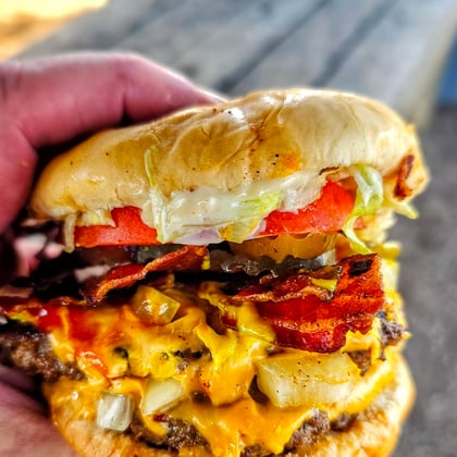 A double bacon cheeseburger with chili, onions and melted cheese