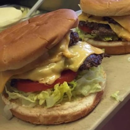 A double cheeseburger with lettuce and tomato