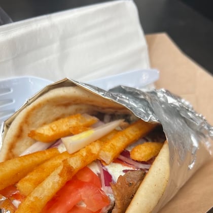 A gyro stuffed with fries and tomato