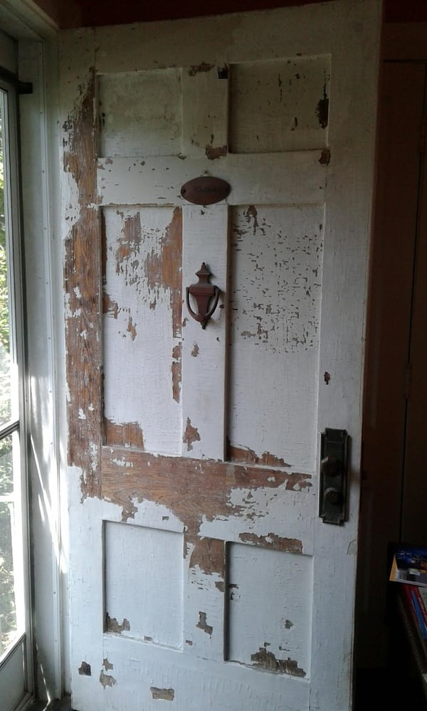Old front door with layers of peeling, cracked paint