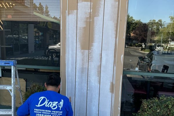 Diaz painter prepping a storefront column