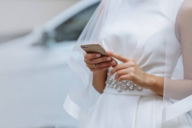 Elegant bride with phone in hands on a white background