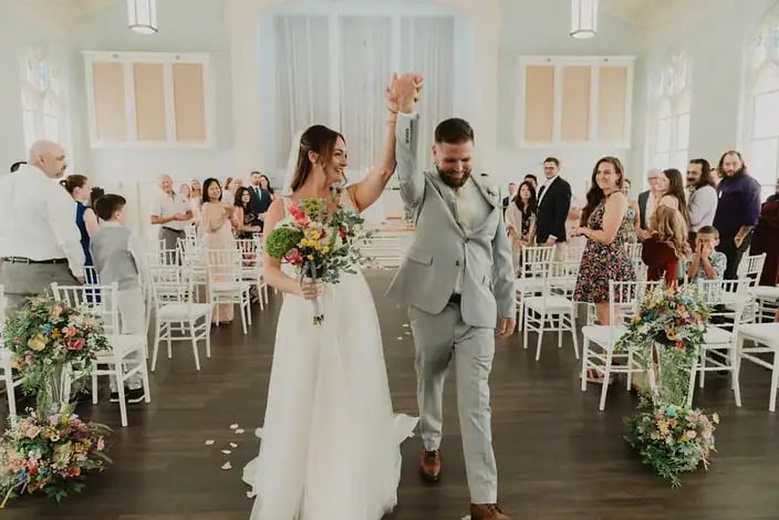 Newlyweds celebrating at the end of their ceremony in the Blackburn Ballroom