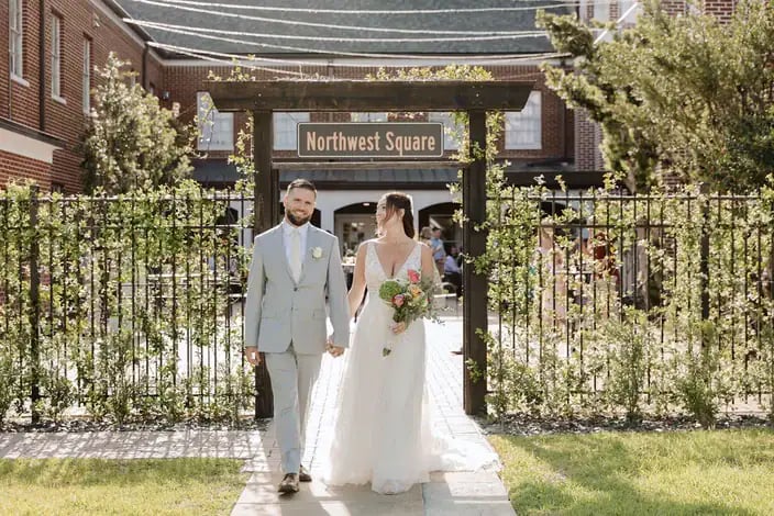 Bride and groom walking through the Northwest Square courtyard gate