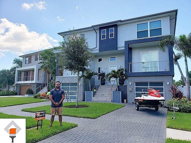 Prodigious Painting team member in front of a freshly painted modern home