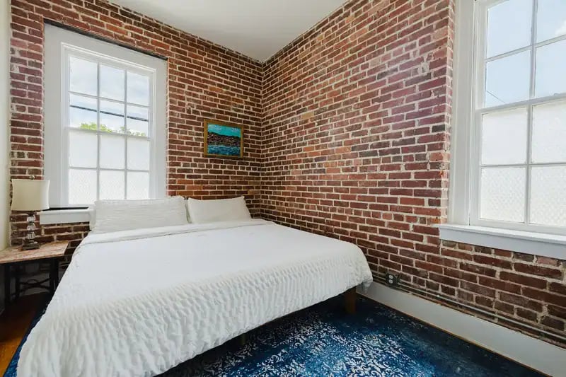 Apartment 201 bedroom with brick walls and original windows