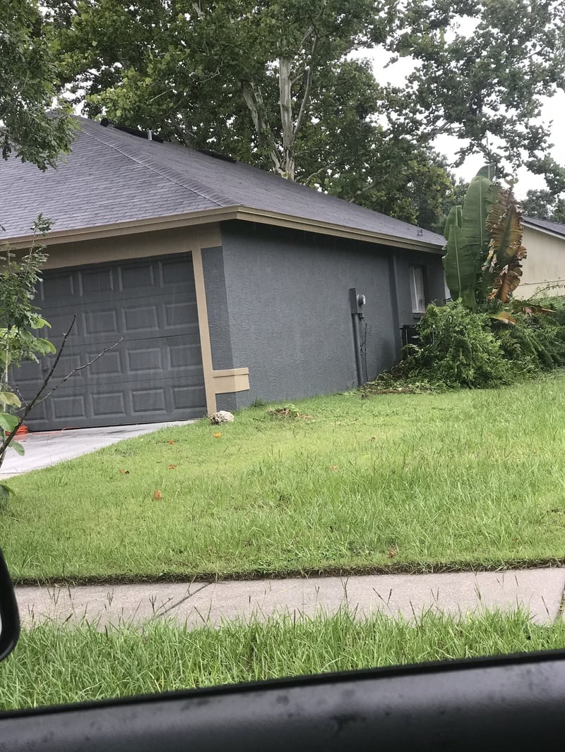 Home exterior freshly painted dark gray with tan trim
